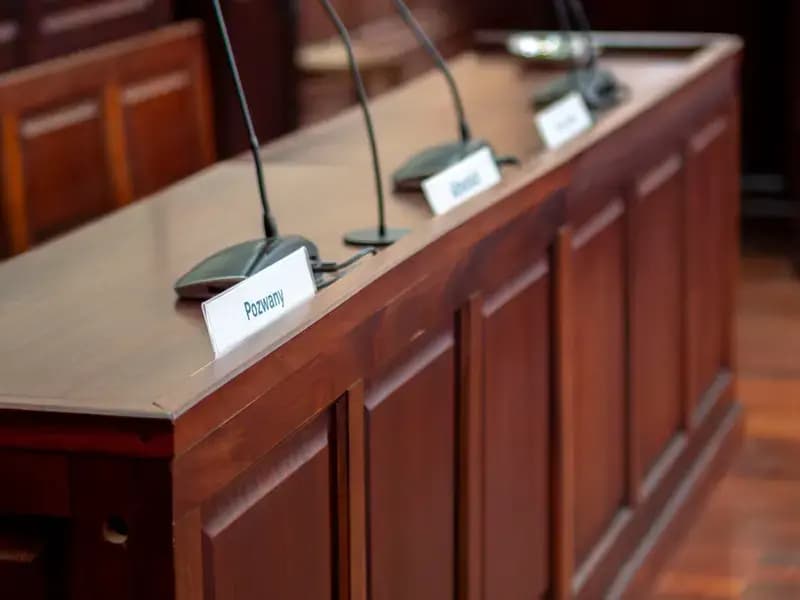 Empty courtroom bench with microphones and nameplates